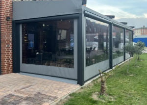 Πέργκολα σε χρώμα ανθρακί με αντιανεμικές ζελατίνες και φωτισμό led.